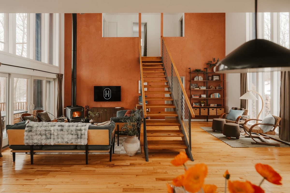 Modern living room with wood floors, fireplace, and open staircase